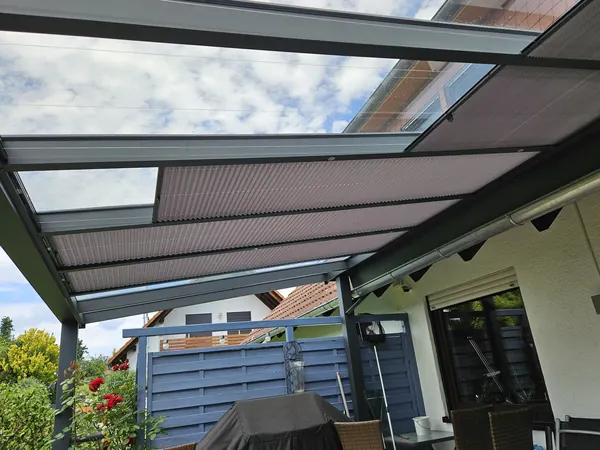 Plissees unter dem Glasdach einer Terrasse